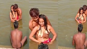 A group of boys give an Indian girl a bath in a river like they are in a porn video.