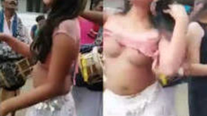Two naked prostitutes dance in a village in front of the people.
