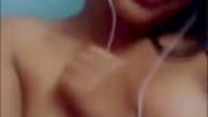 A rather slim build sweet young Indian woman in a blue sweater on a video call.